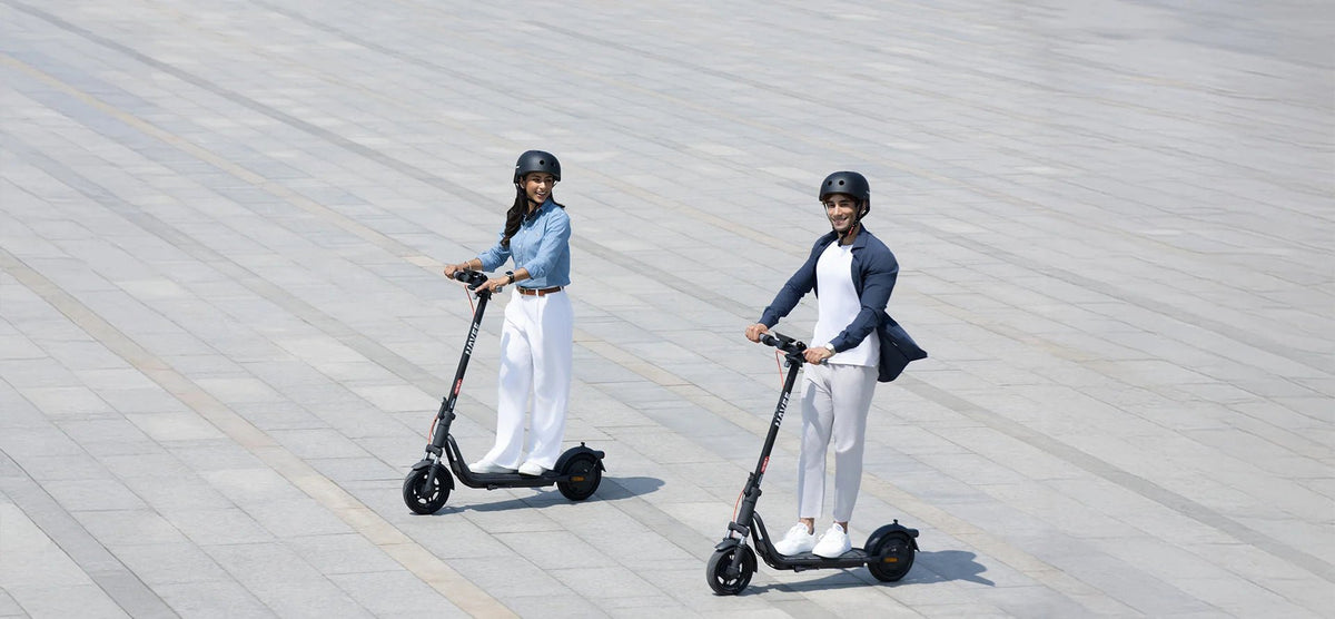 Persona alla guida del monopattino elettrico NAVEE V25i Pro II in città in gruppo