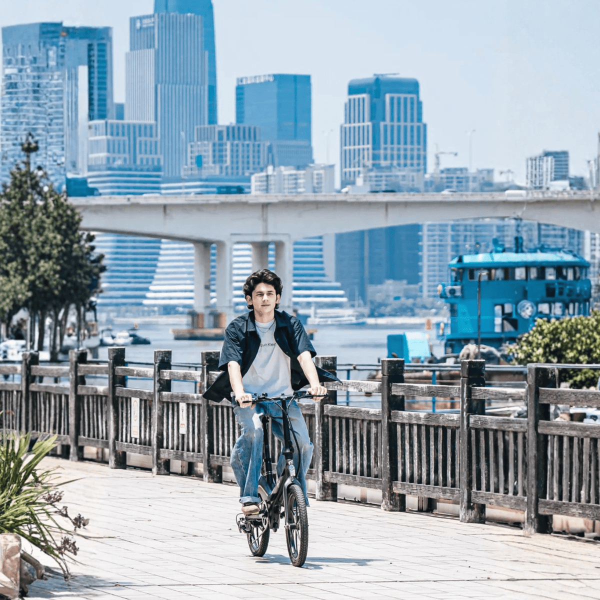 Uomo alla guida della bici elettrica pieghevole ONEBOT Eagle su un vialetto
