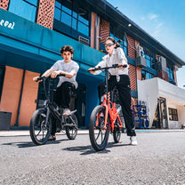 Due persone con la bici elettrica pieghevole ONEBOT Eagle in città