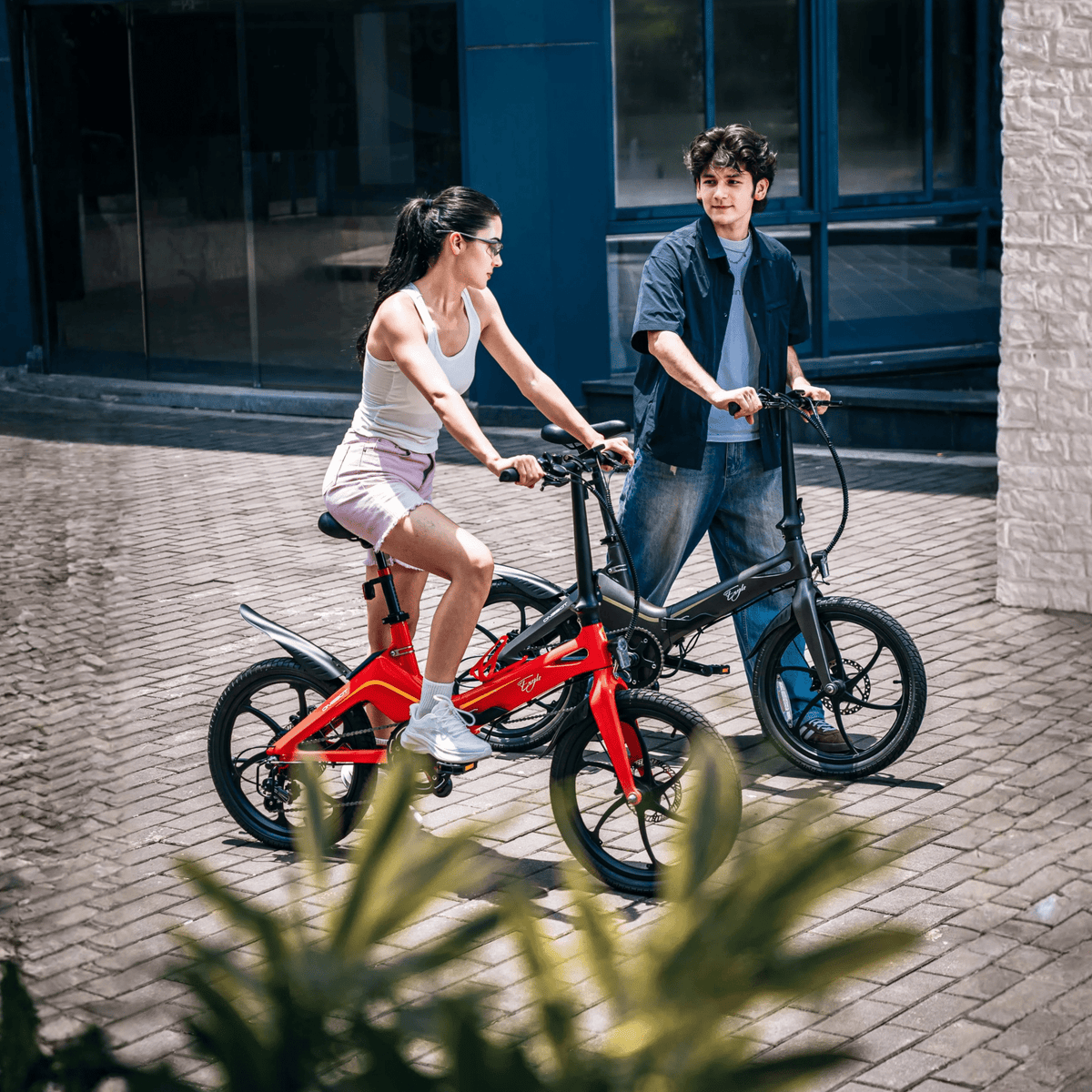 Due persone con la bici elettrica pieghevole ONEBOT Eagle in una strada