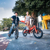 Due persone con la bici elettrica pieghevole ONEBOT Eagle in un parco