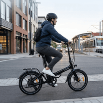 Uomo alla guida della bici elettrica pieghevole Onemile E2 su strada