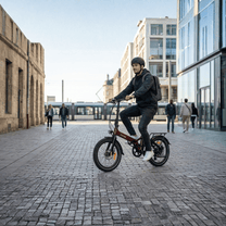 Uomo alla guida della bici elettrica pieghevole Onemile E2 in una strada