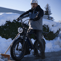 Uomo in piedi con la fat bike elettrica Onemile P40 Pro sulla neve
