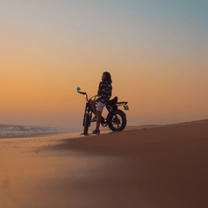 Persona alla guida della fat bike elettrica Onemile P40 Pro al tramonto