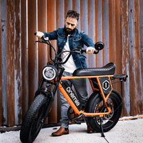 Uomo in piedi con la fat bike elettrica Onemile P40 Pro in colore arancione
