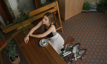Persona che porta la bici elettrica pieghevole OneSport OT02 piegata dall'alto