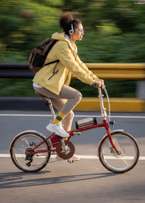 Donna alla guida della bici elettrica pieghevole OneSport OT02 Pro in colore rosso su strada