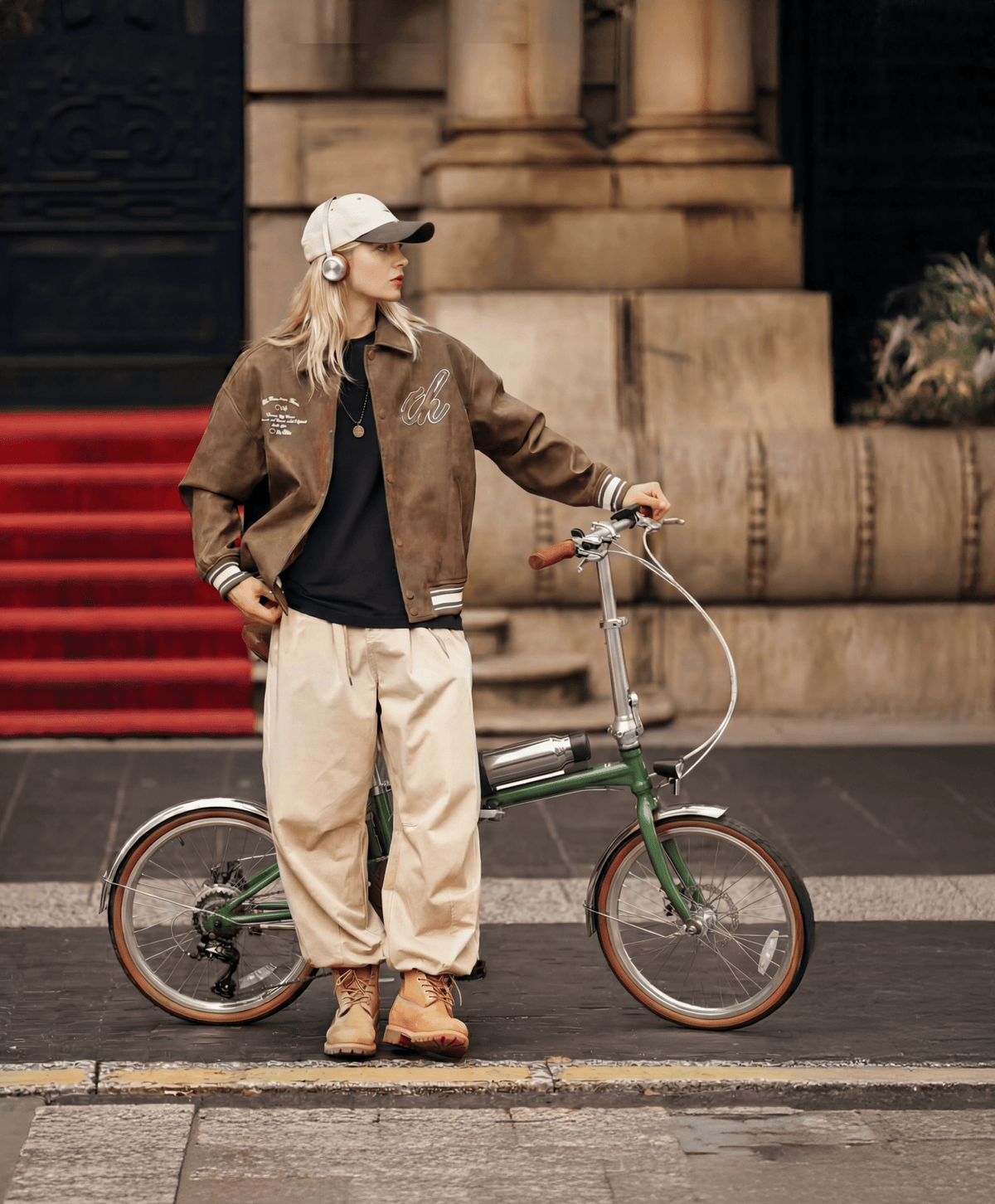 Uomo in piedi con la bici elettrica pieghevole OneSport OT02 Pro in colore verde in una strada