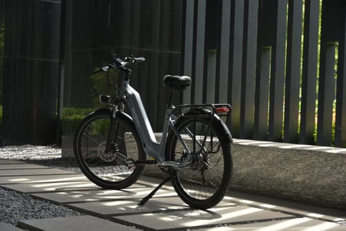 Bici elettrica OneSport OT05 vista di lato parcheggiata al sole