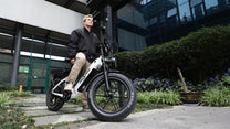 Uomo alla guida della fat bike elettrica OneSport OT08 Pro in colore grigio in città