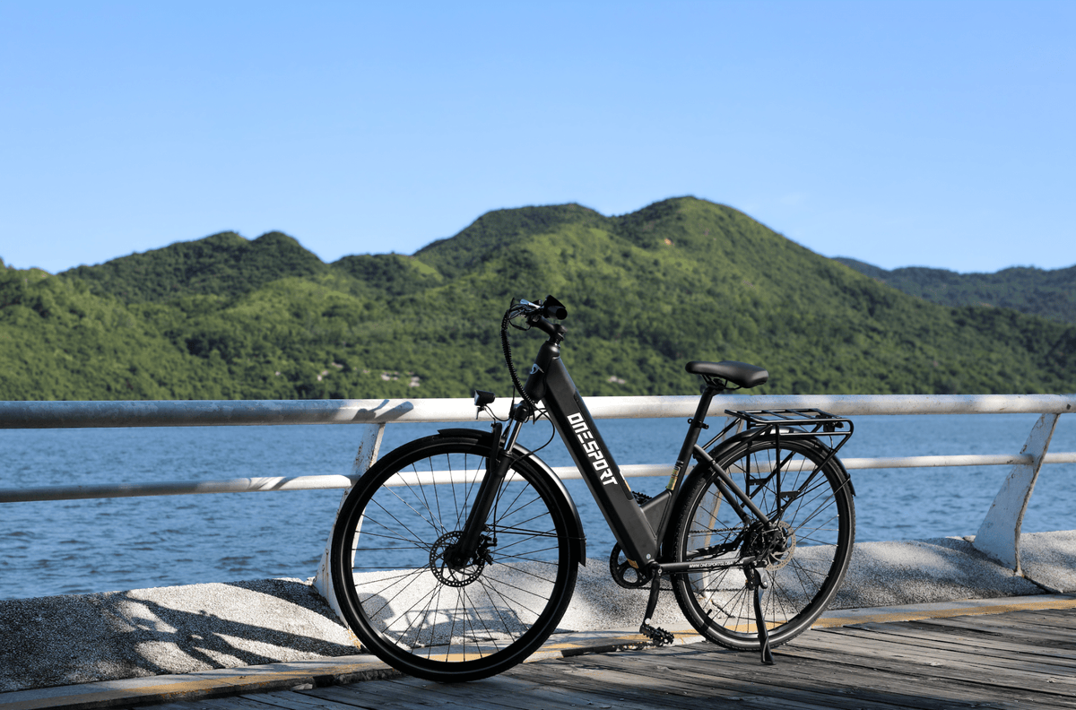 Bici elettrica OneSport OT12 vista di tre quarti in colore nero in riva al mare