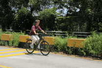 Persona alla guida della bici elettrica OneSport OT12 in colore nero in un parco