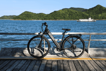 Bici elettrica OneSport OT12 vista di lato in colore nero parcheggiata in riva al mare