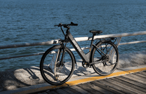 Bici elettrica OneSport OT12 vista di tre quarti in colore nero al tramonto