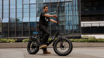 Uomo alla guida della fat bike elettrica pieghevole OneSport OT16 Max in colore nero in città
