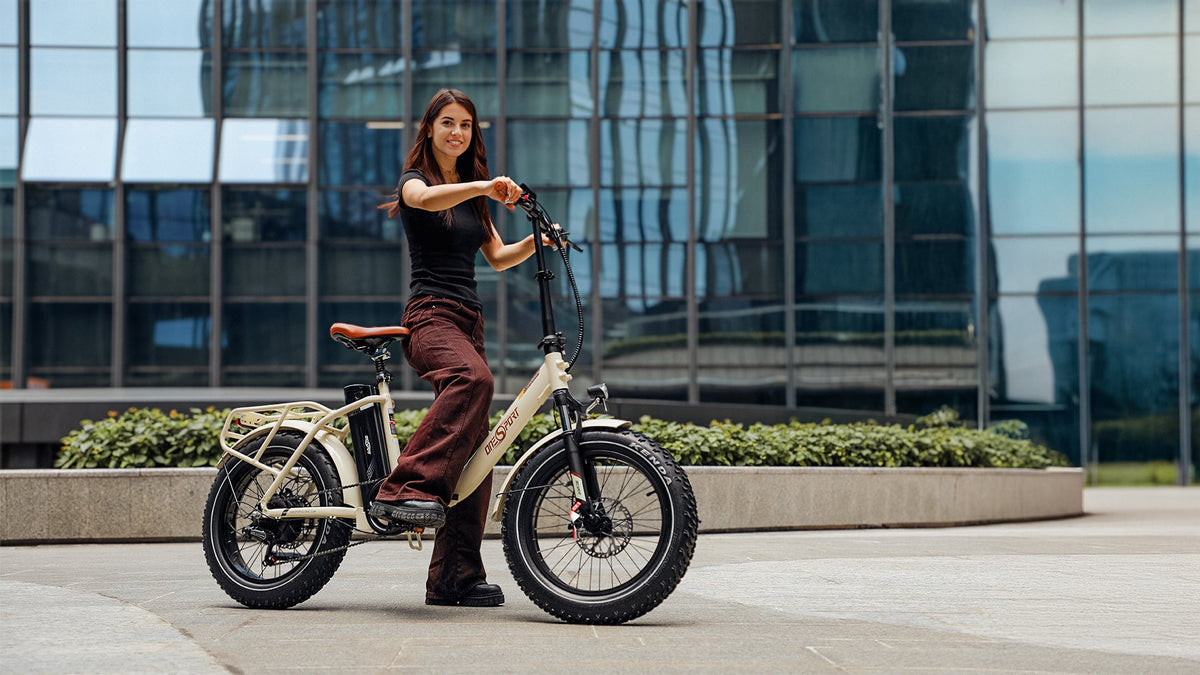 Donna in piedi con la fat bike elettrica pieghevole OneSport OT16 Max in colore beige in città