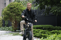 Uomo in sella alla fat bike elettrica OneSport W66 in una strada
