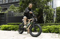 Uomo alla guida della fat bike elettrica OneSport W66 in un parco