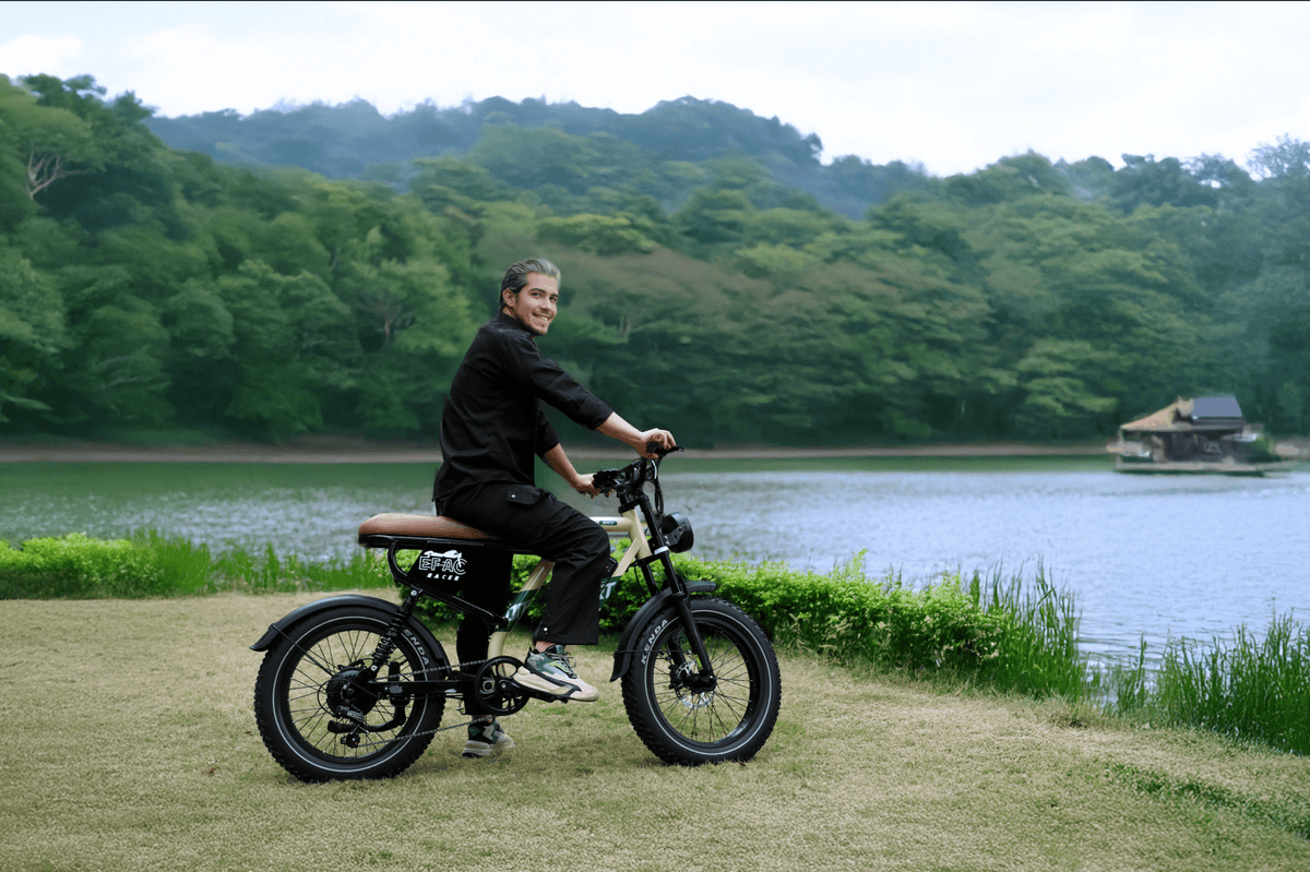 Uomo alla guida della fat bike elettrica OneSport W66 in riva a un lago