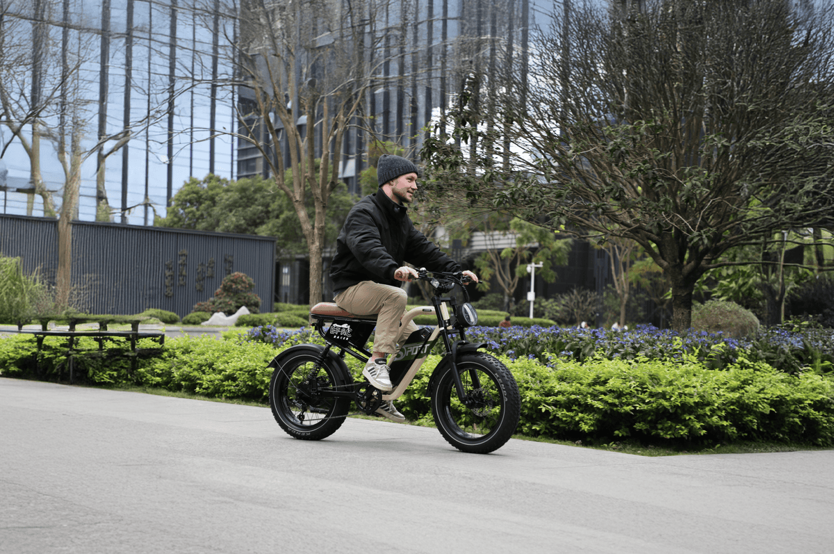 Uomo alla guida della fat bike elettrica OneSport W66 su un vialetto