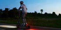 Persona alla guida del monopattino elettrico OOTD T10 Pro al tramonto