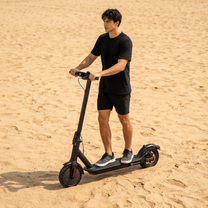 Uomo in piedi con il monopattino elettrico SEEDREAM RED WING MINI su terreno sabbioso