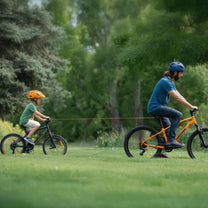 Cavo di traino estensibile smart con gancio per bici mentre traina una bici da bambino