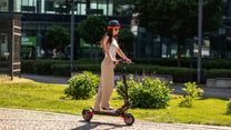 Donna in piedi con il monopattino elettrico TEVERUN BLADE Q PRO in un parco