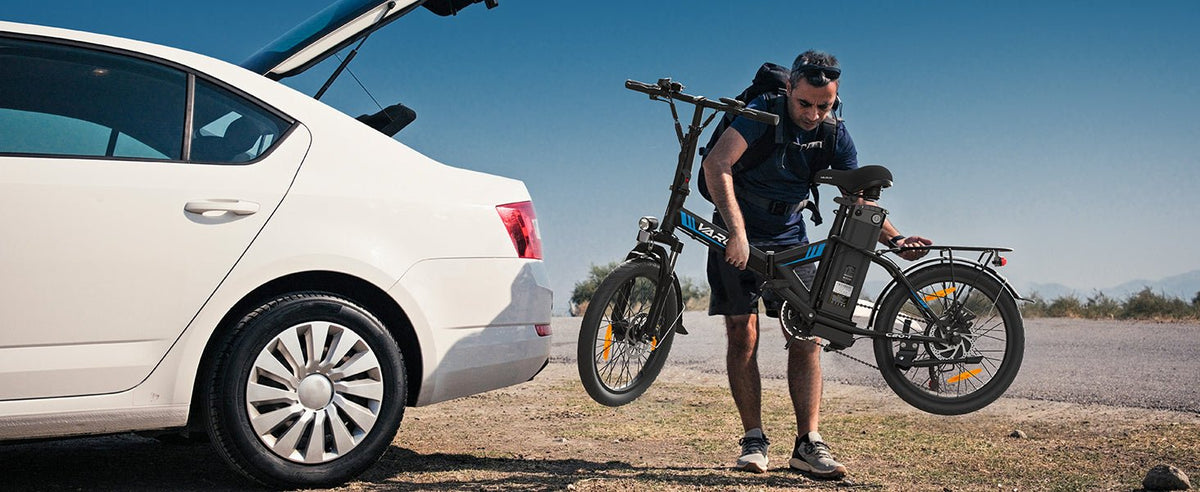 Uomo in piedi con la bici elettrica pieghevole VARUN C20-1 Pro in colore nero