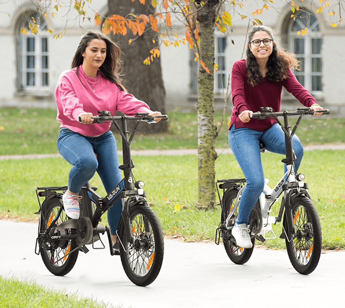 Due persone con la bici elettrica pieghevole VARUN C20-1 Pro in un parco
