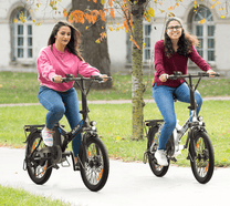 Due persone con la bici elettrica pieghevole VARUN C20-1 Pro in un parco
