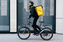 Persona alla guida della mountain bike elettrica VARUN M24-1 in colore nero con il casco in città