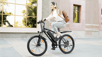 Donna alla guida della mountain bike elettrica VARUN M24-1 in colore nero in città