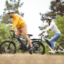 Due persone con la mountain bike elettrica VARUN M24-1 con il casco nel bosco