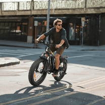 Uomo alla guida della fat bike elettrica VARUN M26-2 Plus in colore nero in una strada