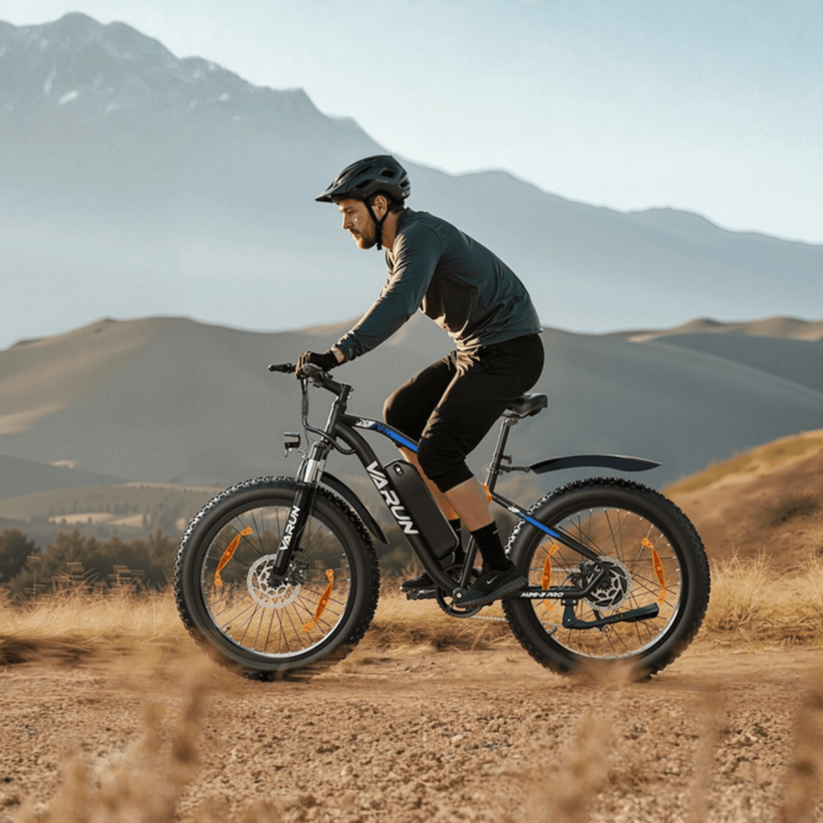 Uomo alla guida della fat bike elettrica VARUN M26-2 Pro in colore nero con il casco nel deserto