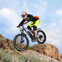 Pilota che salta con la fat bike elettrica VARUN M26-2 Pro con il casco