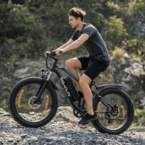 Uomo alla guida della fat bike elettrica VARUN M26-2 Pro in colore nero su una strada sterrata