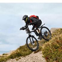 Pilota che salta con la mountain bike elettrica VARUN M26-3 Pro con il casco