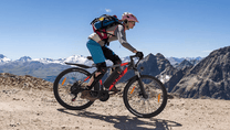 Pilota con la mountain bike elettrica VARUN M27-1 Pro in fuoristrada con il casco in montagna
