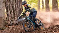 Pilota con la mountain bike elettrica VARUN M27-1 Pro in fuoristrada con il casco nel bosco