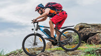 Pilota con la mountain bike elettrica VARUN M27-1 Pro in fuoristrada con il casco