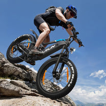 Pilota con la fat bike elettrica VARUN S26-1 in fuoristrada con il casco in montagna