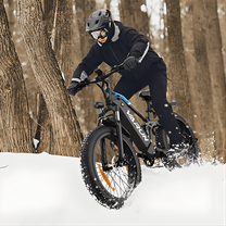 Uomo alla guida della fat bike elettrica VARUN S26-1 in colore nero con il casco sulla neve