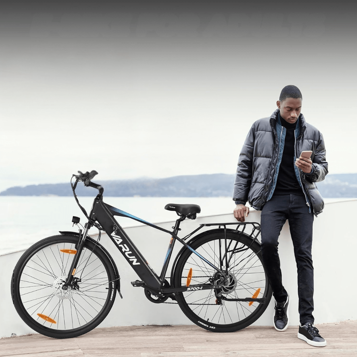 Uomo in piedi con la bici elettrica VARUN S700-1 in colore nero