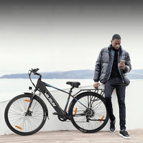 Uomo in piedi con la bici elettrica VARUN S700-1 in colore nero