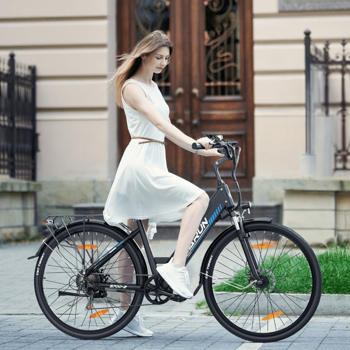 Donna alla guida della bici elettrica VARUN S700-2 in colore nero in città