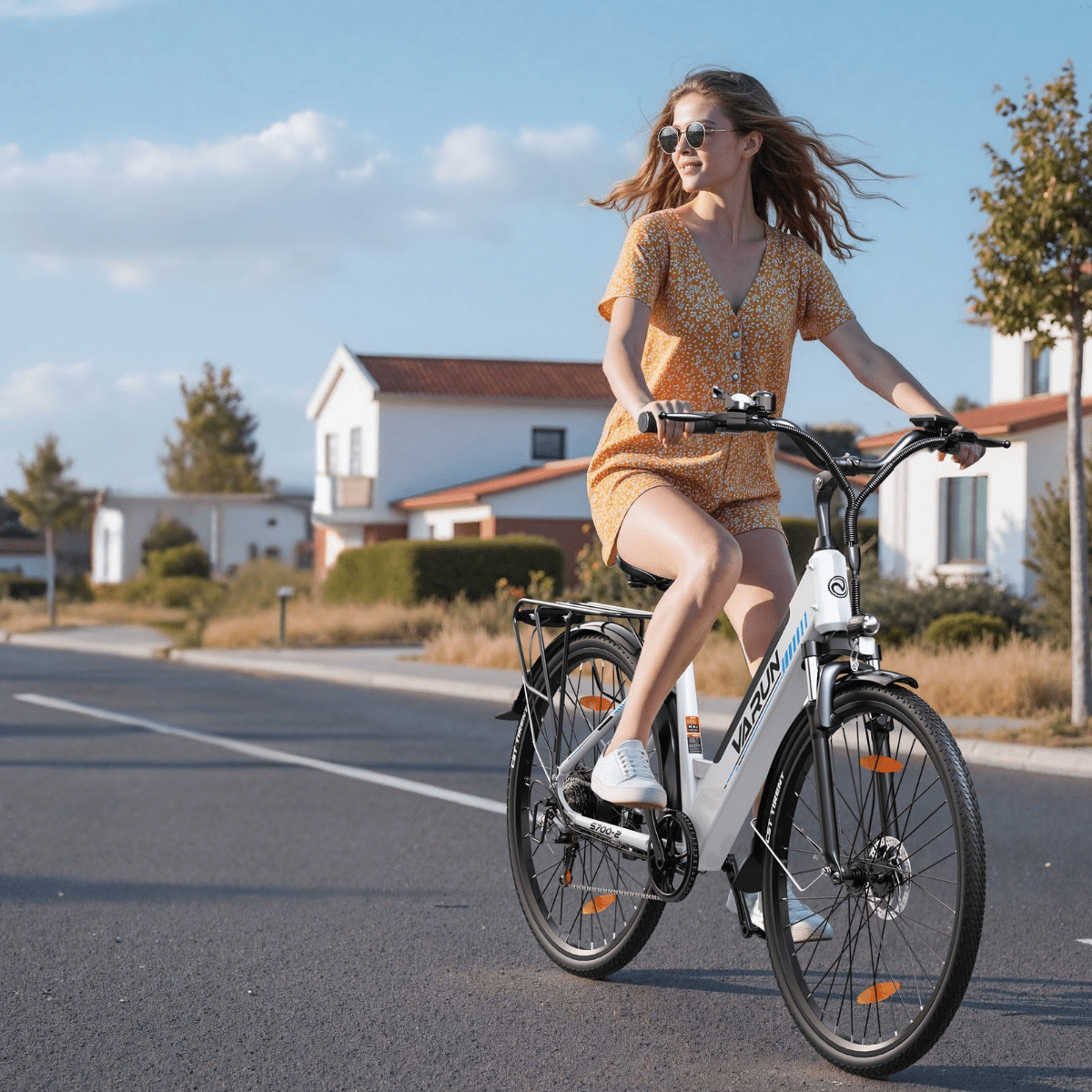 Donna alla guida della bici elettrica VARUN S700-2 in colore bianco in una strada