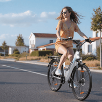 Donna alla guida della bici elettrica VARUN S700-2 in colore bianco in una strada